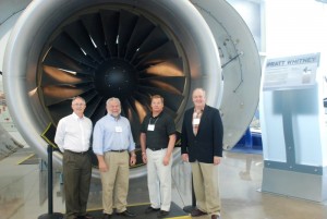 Tim Grieves (Iowa), Mark Freeman (Ohio), Scott Palczewski (Michigan) and Doug Hesbol (Illinois) in front of Pratt and Whitney engine